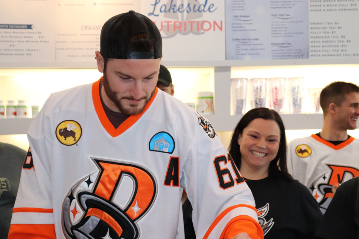 A hockey player works behind the counter.