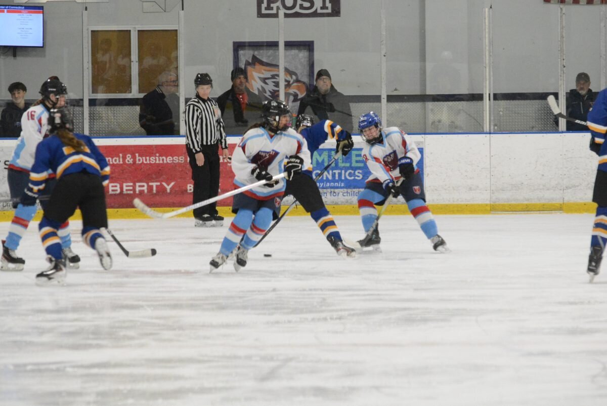 Carly Leventakos looks to break out of the defensive zone as Grace Douglas moves the puck.