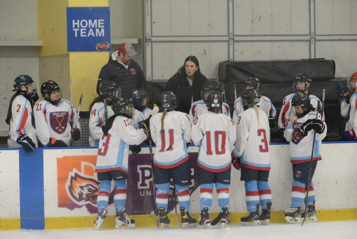 Assistant Coach Matthew Rowley and Head Coach Carly Bokina talk to players during a timeout.