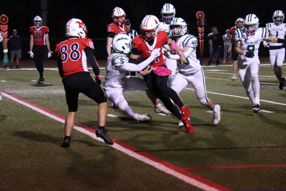 Quarterback Aaron Champagne plows through two tacklers while scoring the Panthers' first TD of the night.
