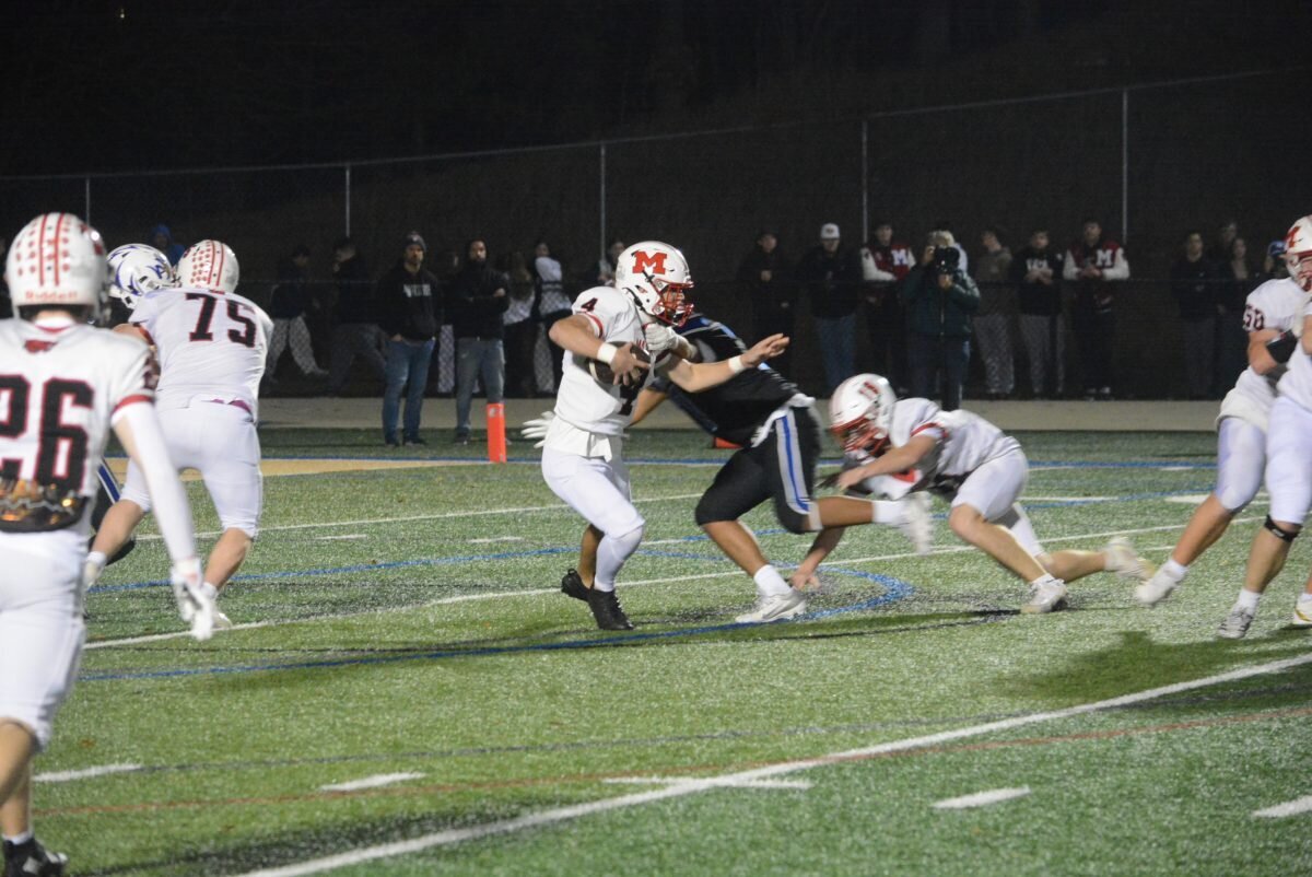 Masuk quarterback Aaron Champagne tries to avoid a sack.