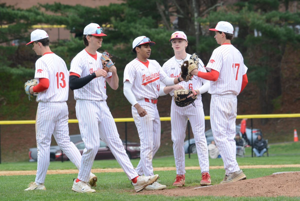 Masuk players meet at the mound.