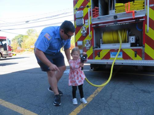 Capt. Chris Krize helps his daughter, MacKenzie, 3, use a firehose at the MVFD open house.